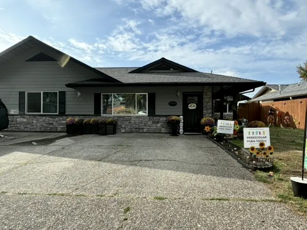 Front of the house on SE Millmain Dr with the daycare and preschool signs out front