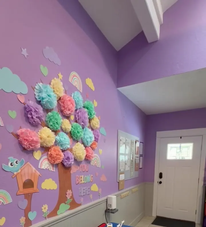 Purple classroom wall with a paper tree that reads You Belong Here